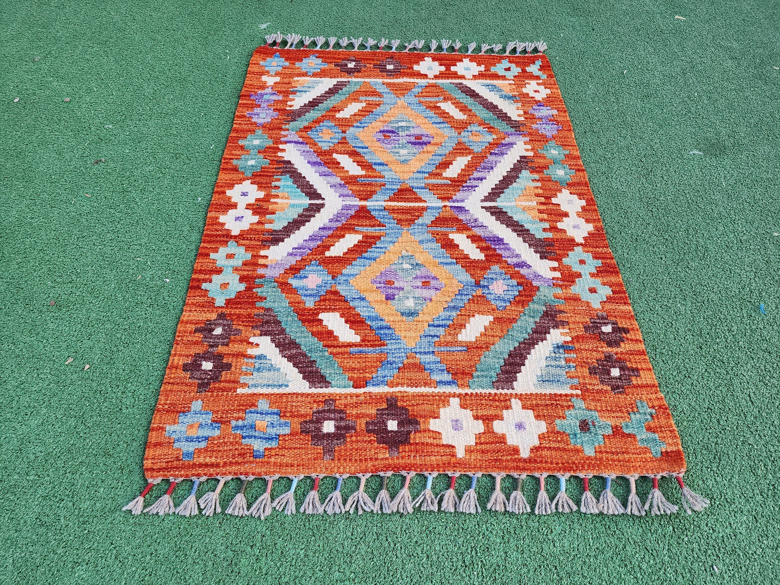 Vintage hand-knotted rug photographed in natural daylight on a neutral background