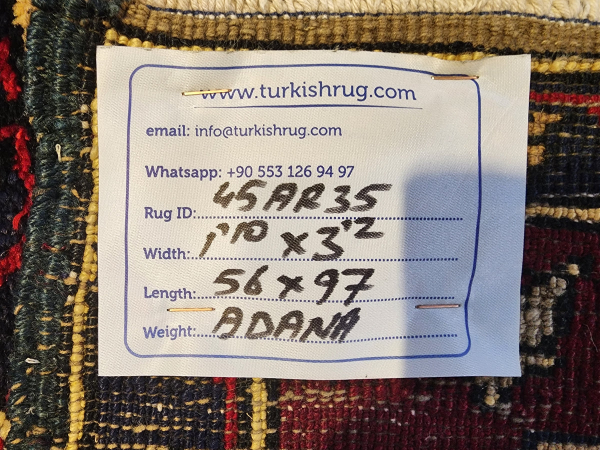 Vintage Adana rug in red, blue and beige, 1'10" x 3'2", back of the rug with the hand-written label
